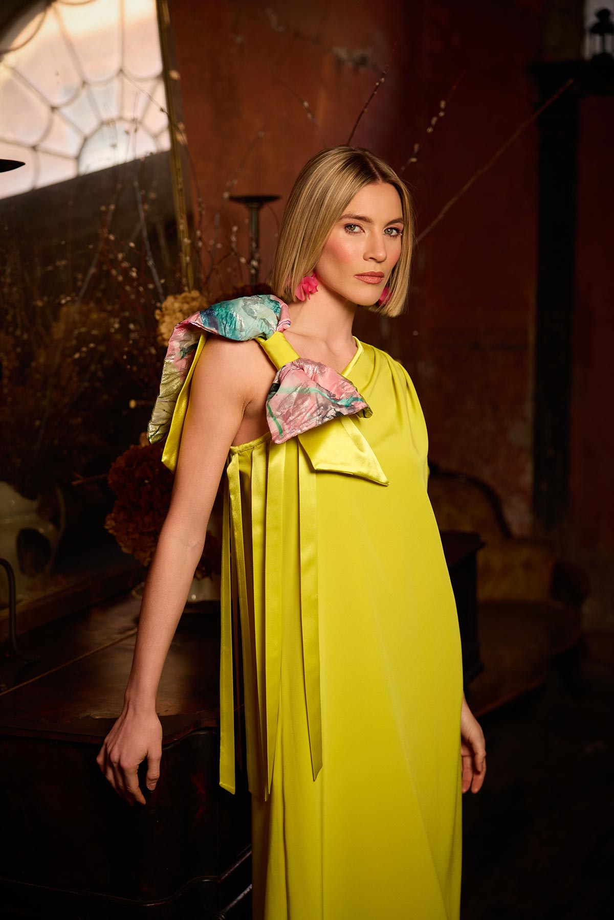Woman wearing a yellow dress with floral accents in an indoor setting