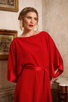 Woman wearing a red dress in an indoor setting with classical decor
