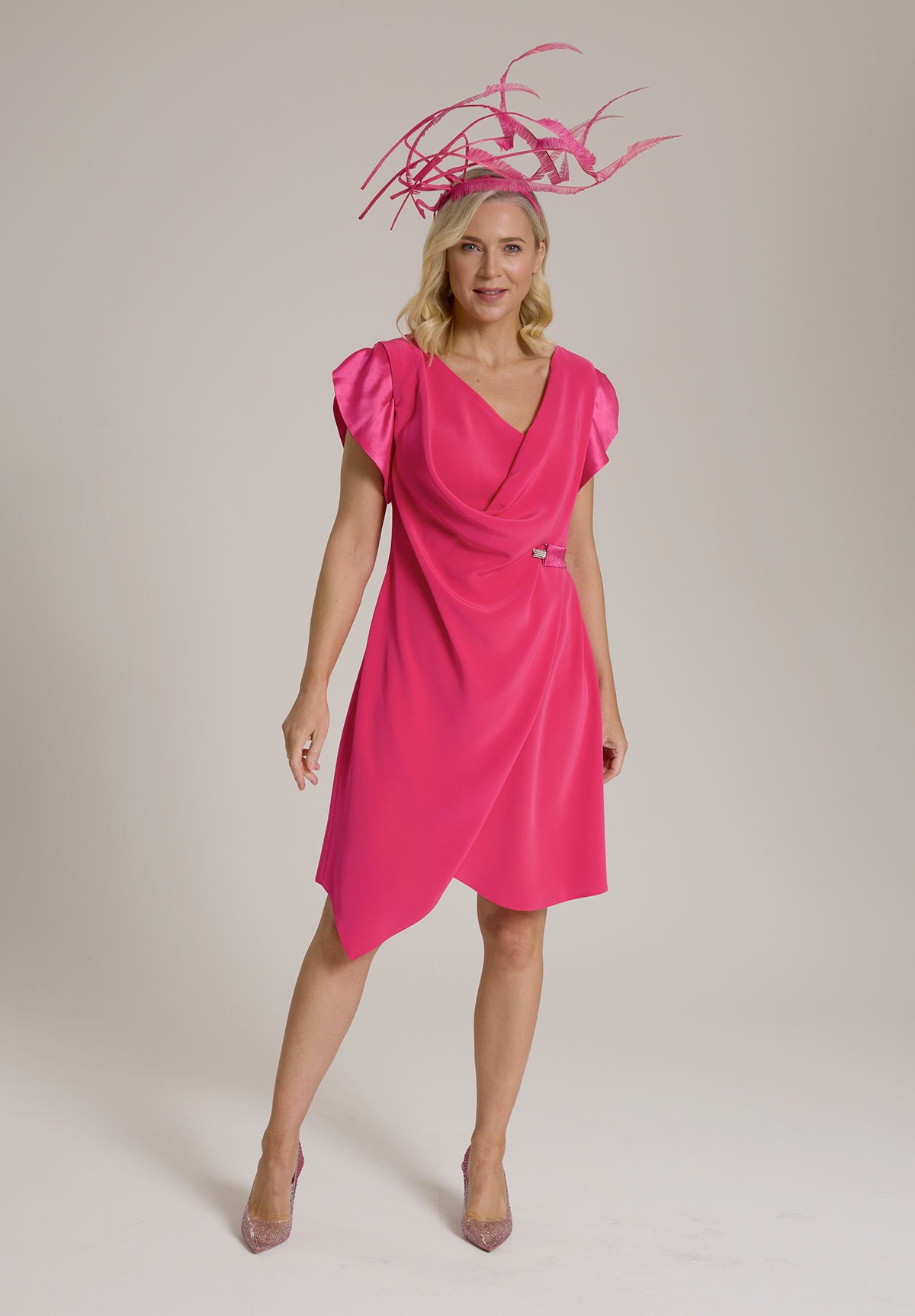 Monessa Joan pink Ailbhe Dress, paired with elaborate pink fascinator and heels.