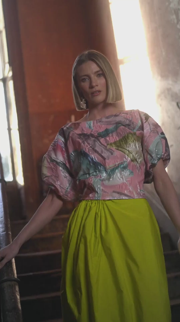 Videoof a Woman wearing a colorful blouse and duck egg pants.