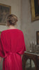 video of a woman wearing a red dress in a room with classical decor