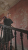 video of a woman in a black dress with sequin shoulder bow