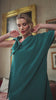 video of a blonde woman wearing a teal dress